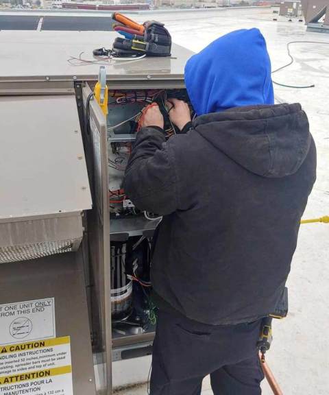 One of our dedicated service technicians working on an HVAC unit